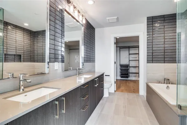 a bathroom with a granite countertop sink and a bathtub