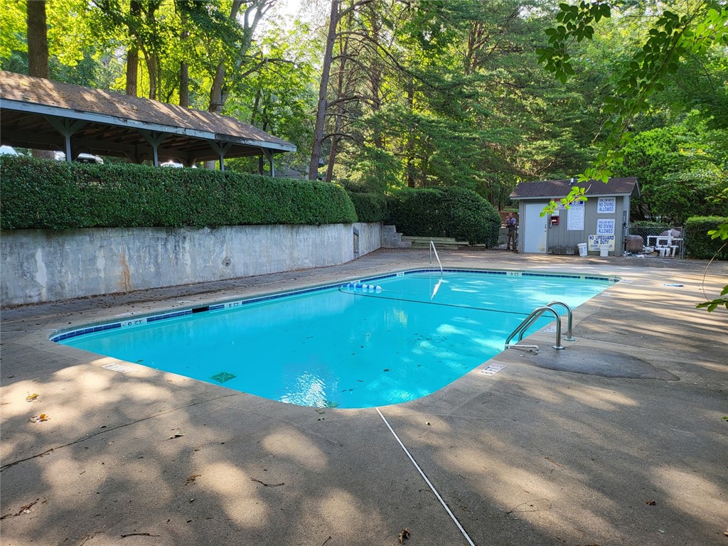 150 Ligon Street, Unit 1001 Clemson, SC 29631 - Photo 26 of 29 A private community pool area, surrounded by lush green foliage and mature trees, offers a relaxing retreat.