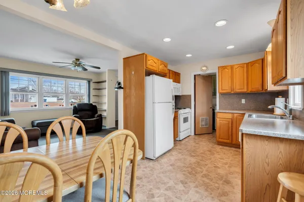 a kitchen with granite countertop a refrigerator a sink and wooden cabinets
