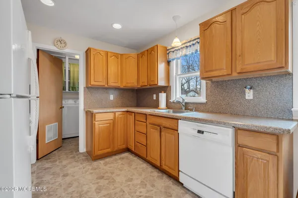 a kitchen with stainless steel appliances granite countertop a refrigerator a stove top oven a sink and dishwasher
