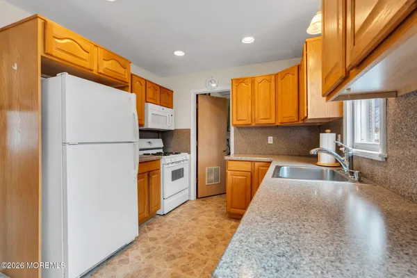 a kitchen with stainless steel appliances granite countertop a stove a sink and a refrigerator