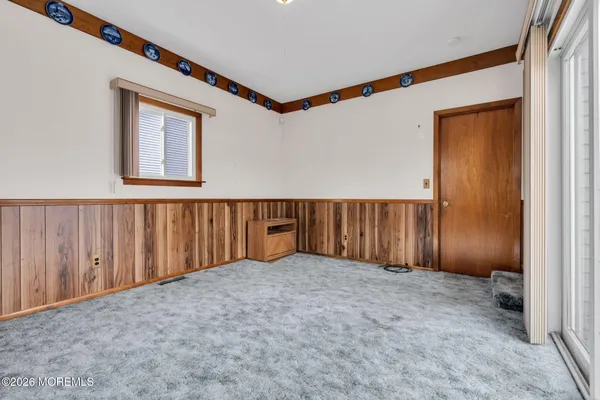 a view of a room with a large window and wooden floor
