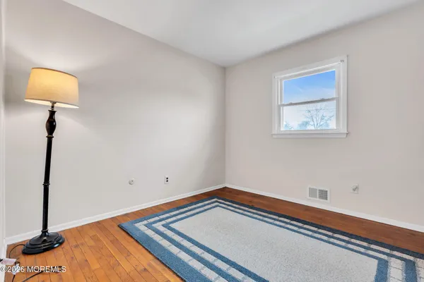 a view of room with window and wooden floor