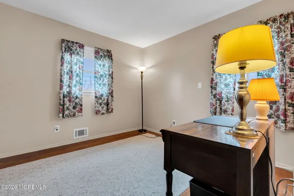 a view of a house with backyard wooden table and chairs