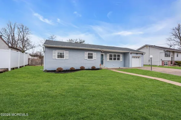 a view of a white house with a big yard