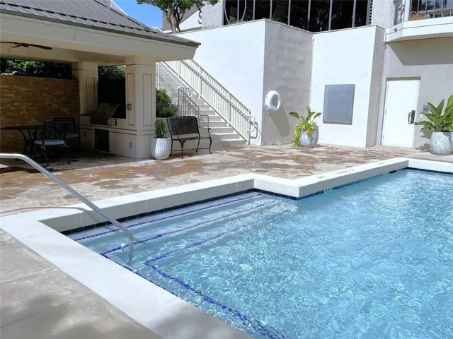 a living room with furniture a flat screen tv and a floor to ceiling window
