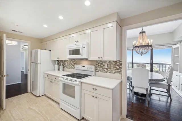a kitchen with a white cabinets and chairs