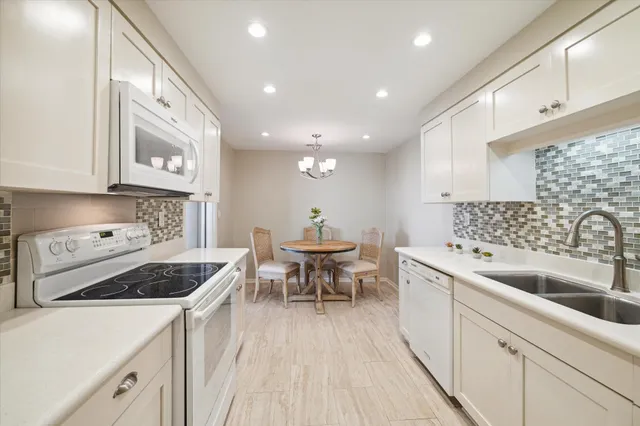 a dining room with wooden floor and chandelier