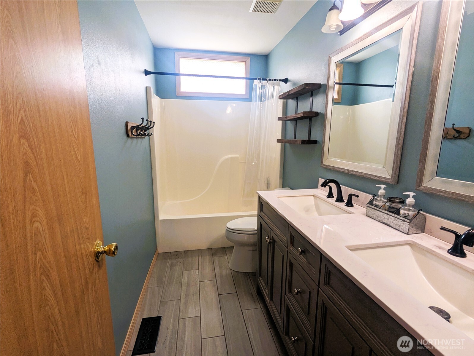 9441 180th Way Southwest Rochester, WA 98579 - Photo 16 of 37 a bathroom with a double vanity sink a toilet and shower