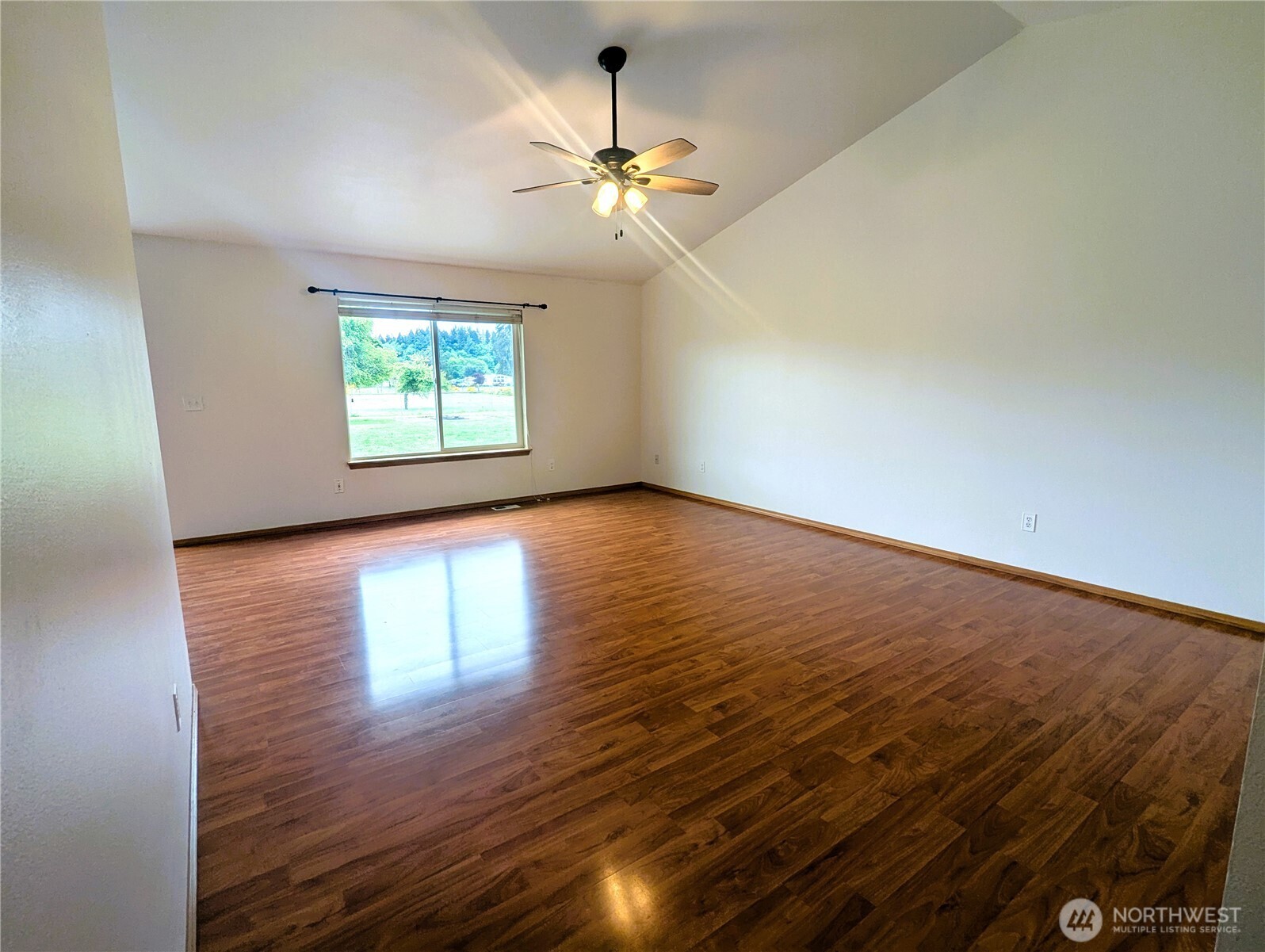 9441 180th Way Southwest Rochester, WA 98579 - Photo 8 of 37 an empty room with wooden floor chandelier fan and windows
