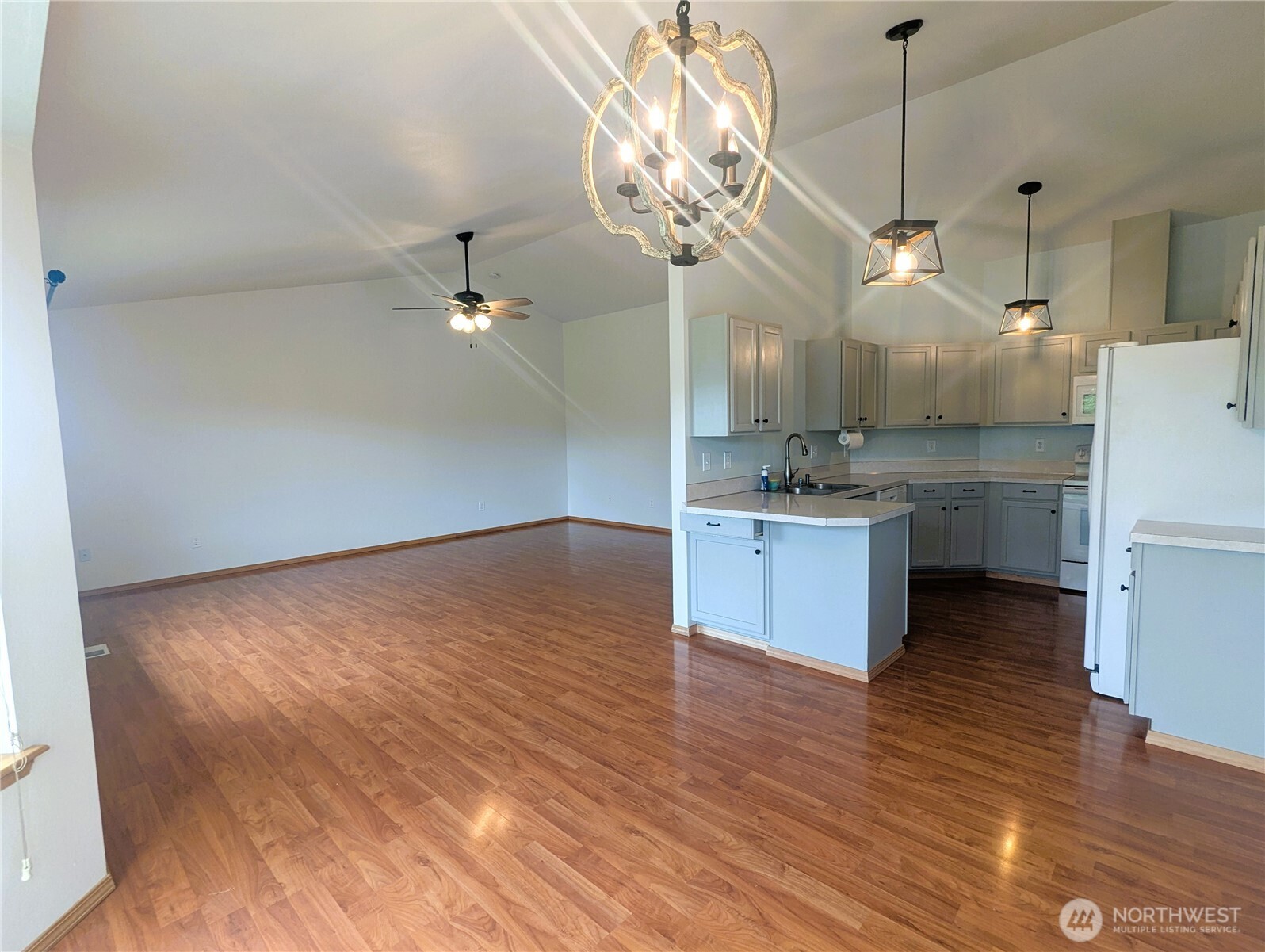 9441 180th Way Southwest Rochester, WA 98579 - Photo 10 of 37 a kitchen with kitchen island a counter top a stove a refrigerator and a chandelier