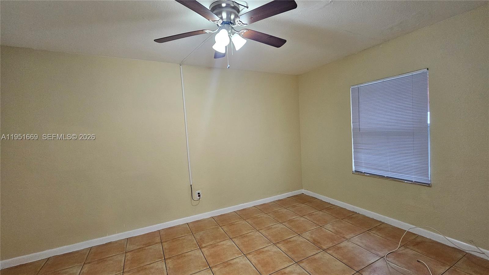 1848 Madison Street, Unit 3 Hollywood, FL 33020 - Photo 6 of 11 an empty room with a chandelier fan and windows
