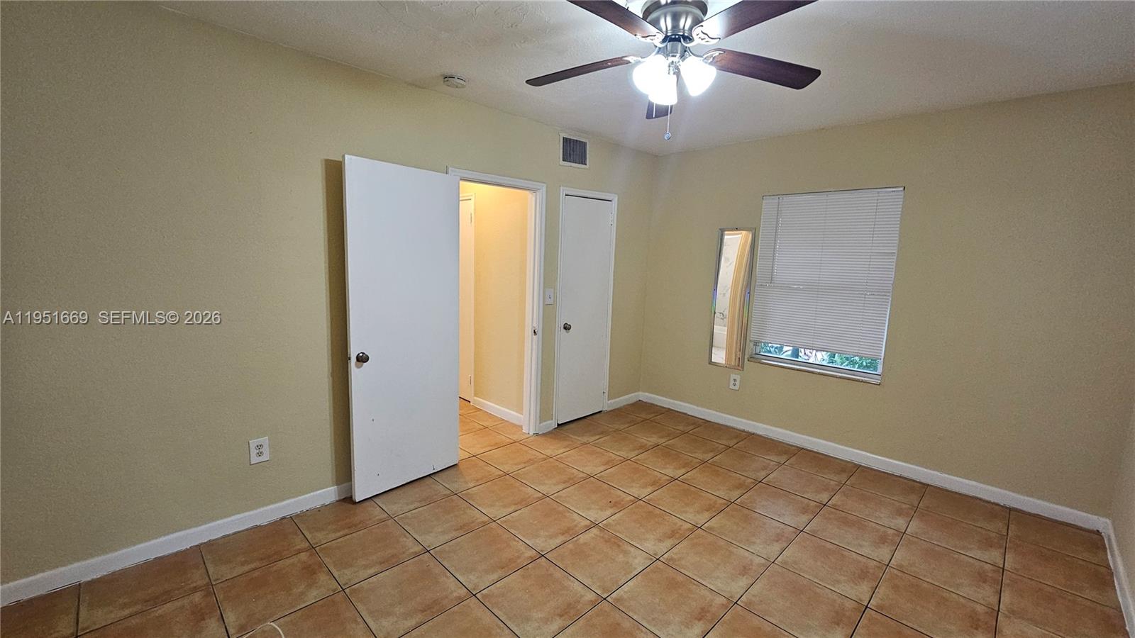 1848 Madison Street, Unit 3 Hollywood, FL 33020 - Photo 7 of 11 a view of an empty room with window and chandelier fan
