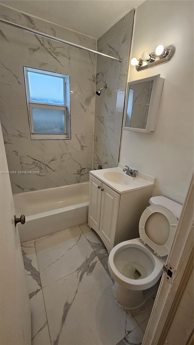 1848 Madison Street, Unit 3 Hollywood, FL 33020 - Photo 8 of 11 a bathroom with a toilet a sink and bathtub