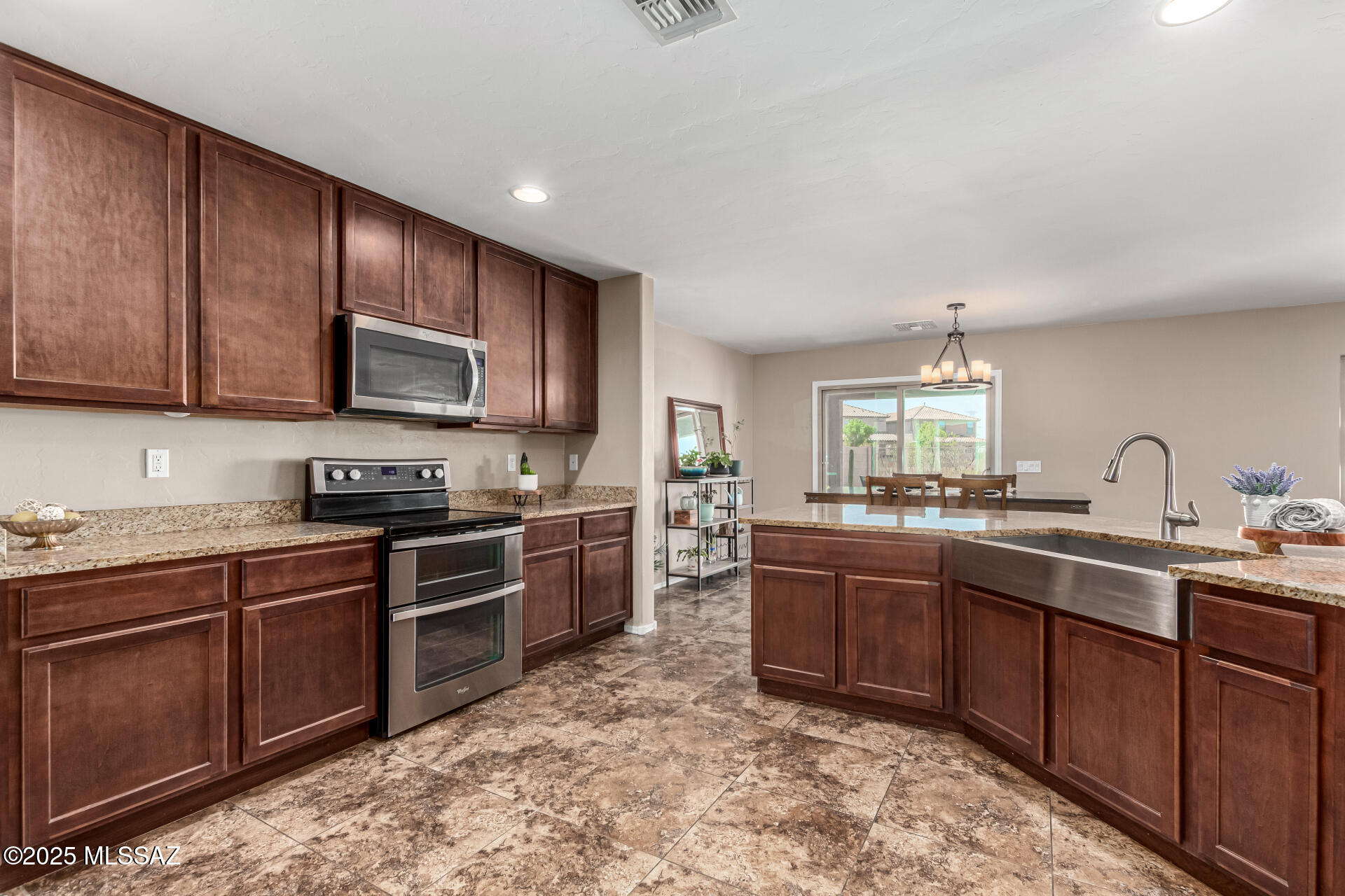9528 Desert Fauna Loop Tucson, AZ 85747 - Photo 15 of 46 a kitchen with lots of counter top space sink and stainless steel appliances