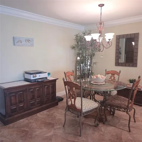 a view of a dining room with furniture a chandelier and wooden floor