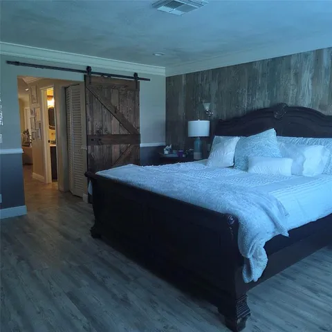 a spacious bedroom with a bed and a mirror