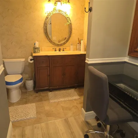 a bathroom with a sink mirror vanity and toilet