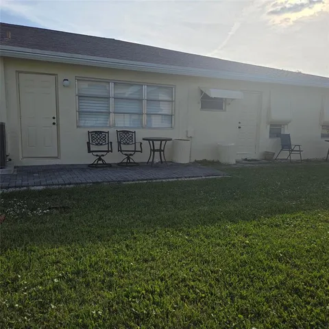 a backyard of a house with table and chairs