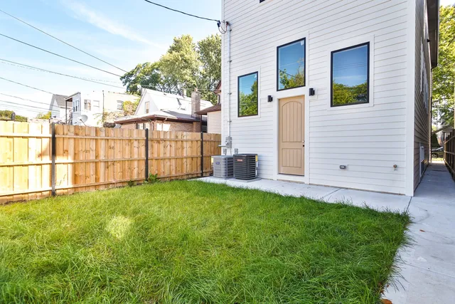 a view of a backyard with plants and large trees