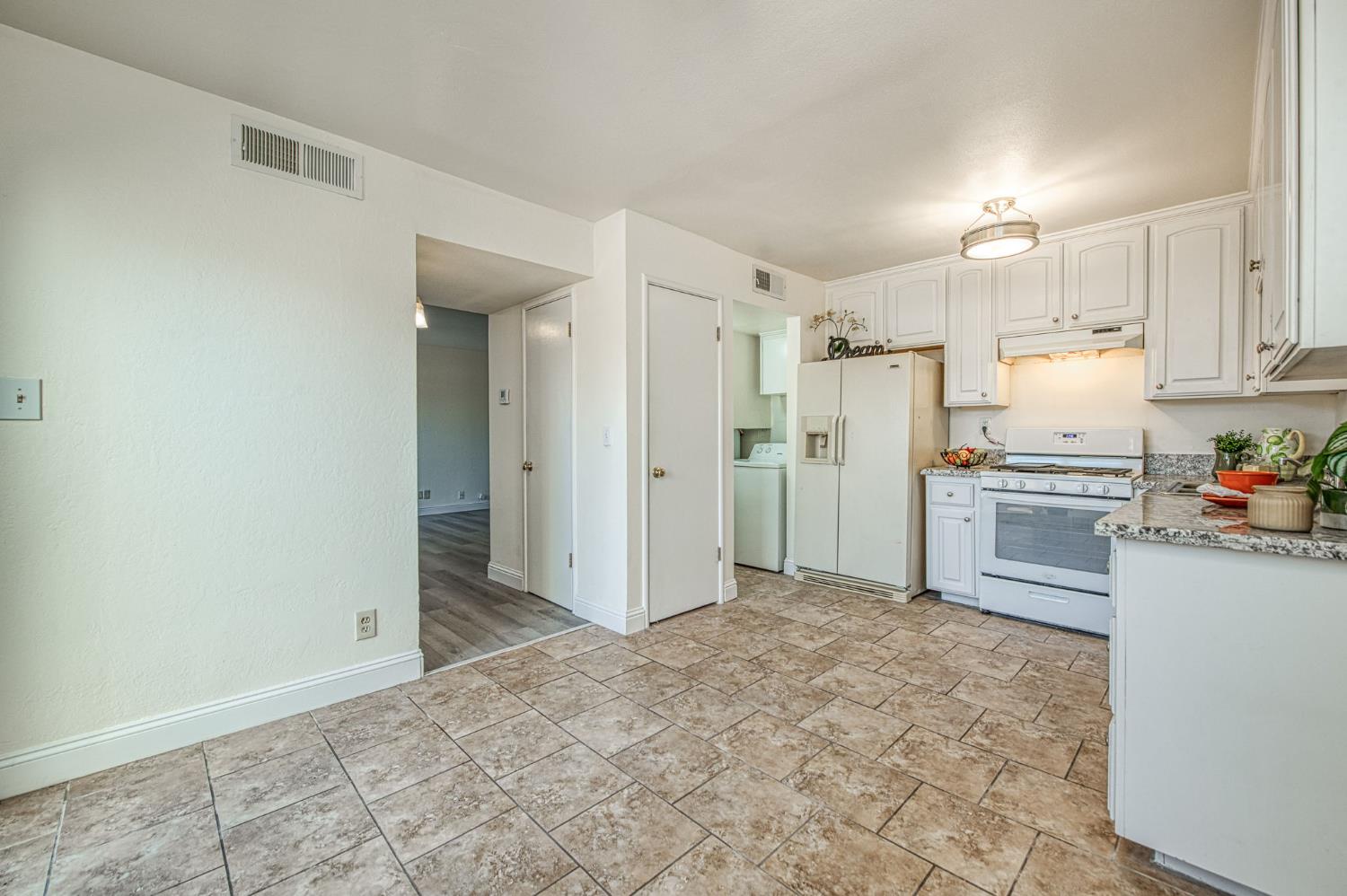 6656 North 3rd Street Fresno, CA 93710 - Photo 14 of 31 a kitchen with white cabinets and stainless steel appliances