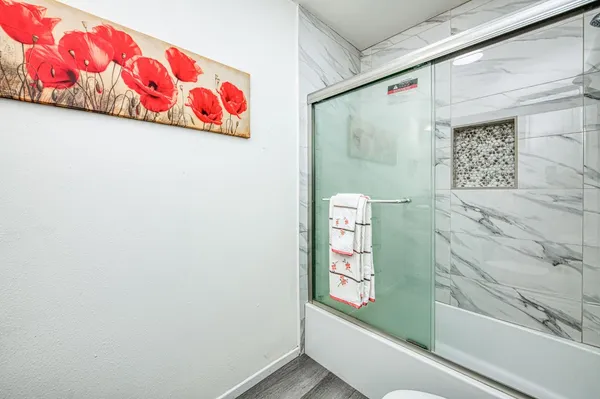 a view of backyard with large trees and wooden fence