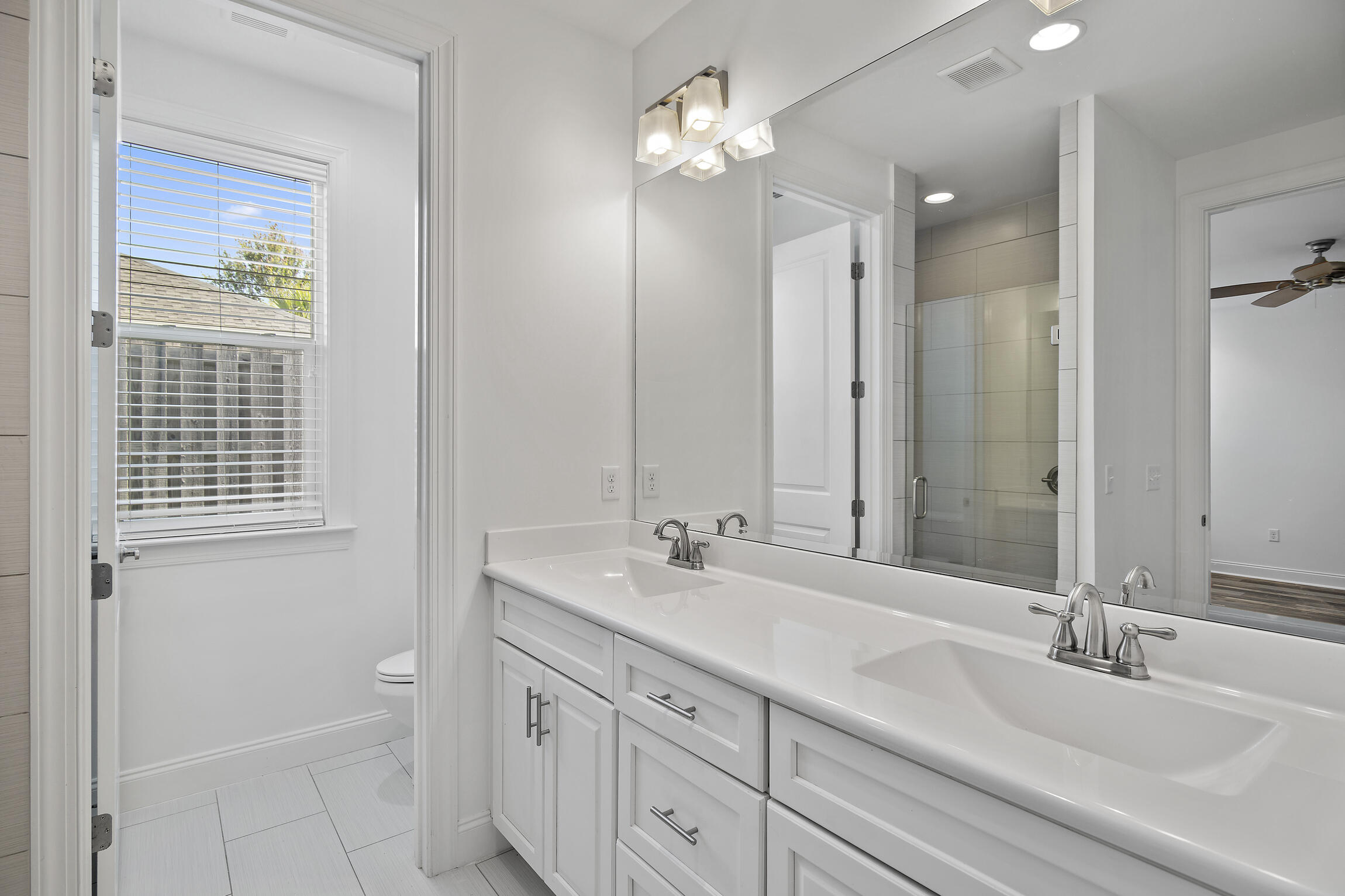 193 Christian Drive Santa Rosa Beach, FL 32459 - Photo 20 of 41 a bathroom with double vanity sinks a vanity two mirror and a shower