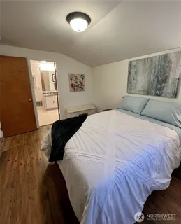 a bedroom with a bed and wooden floor