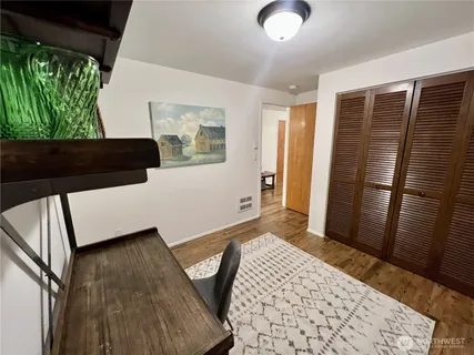 a view of a bedroom with wooden floor and a window
