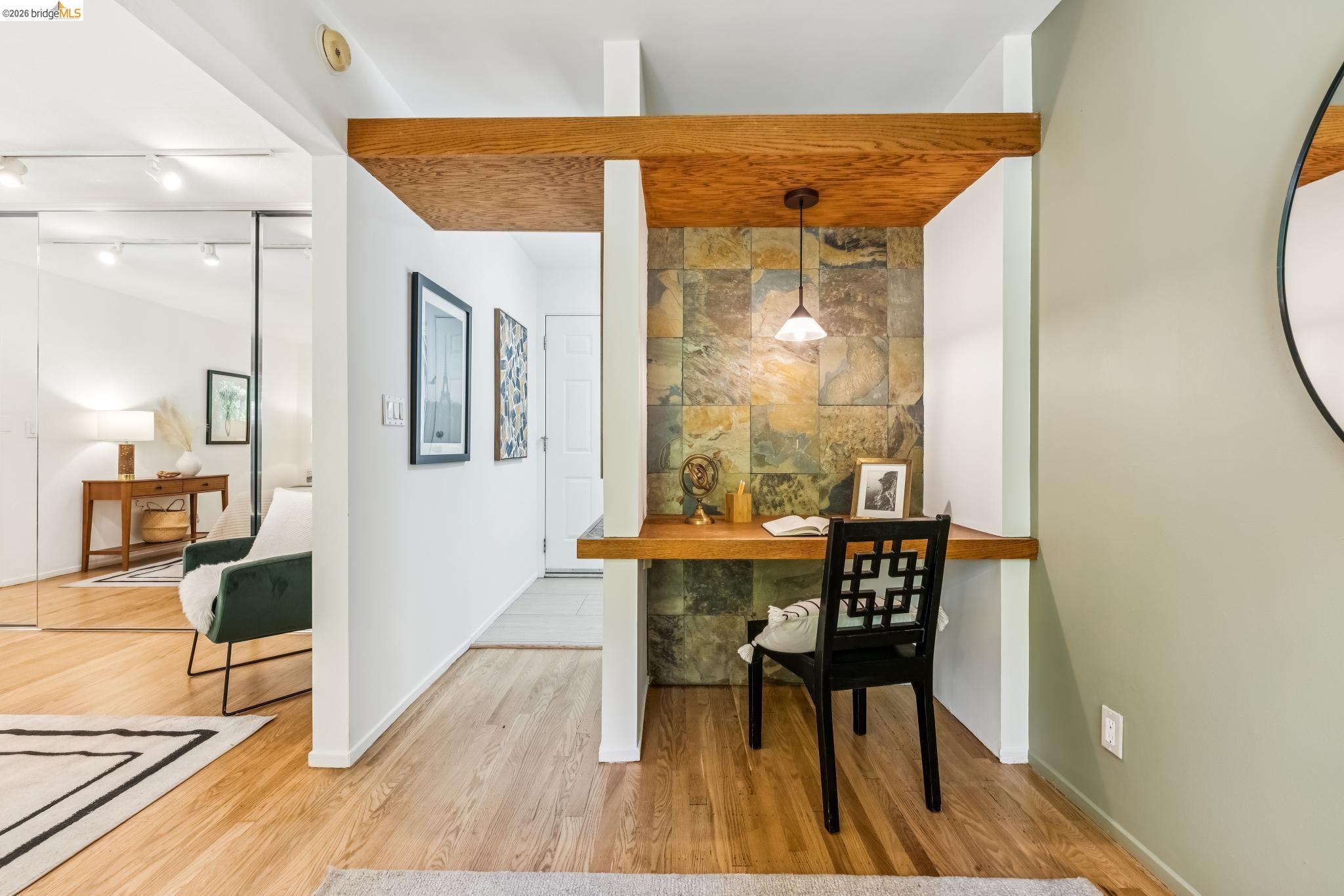 6645 Heather Ridge Way Oakland, CA 94611 - Photo 26 of 61 Built-in desk alcove featuring a slate tile wall, wood-finish desktop, and overhead pendant lighting