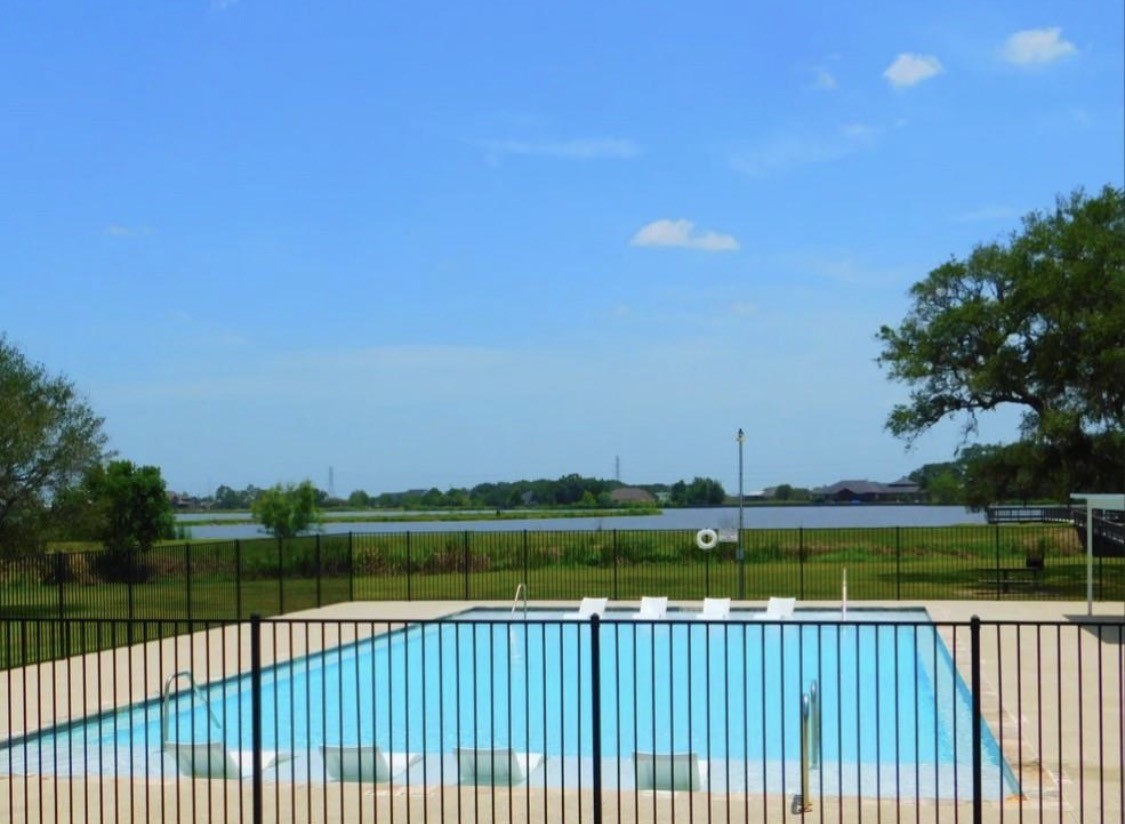 345 Sandy Trail Angleton, TX 77515 - Photo 14 of 18 a view of a balcony with lake and trees in the background