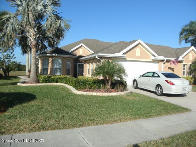 4381 Aberdeen Circle Rockledge, FL 32955 - Photo 1 of 1 a view of a white house with a big yard and palm trees