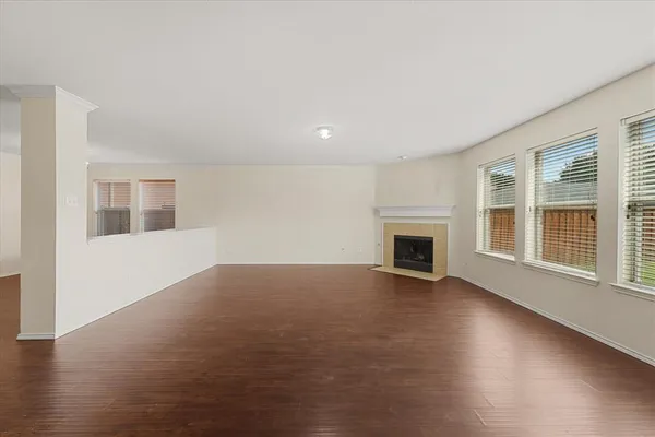a view of empty room with wooden floor and fireplace