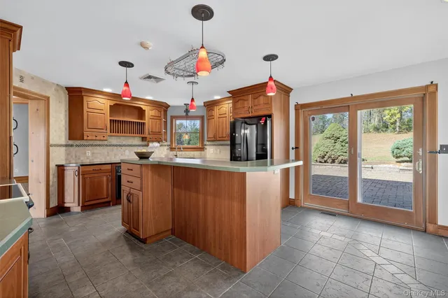 a kitchen with kitchen island granite countertop a stove top oven a sink a counter top space and cabinets