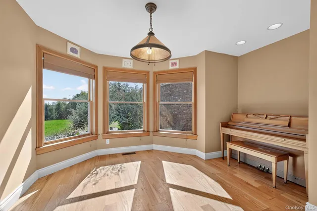 a view of a room with a large window and wooden floor