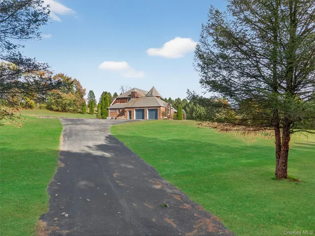 a front view of a house with a yard and trees