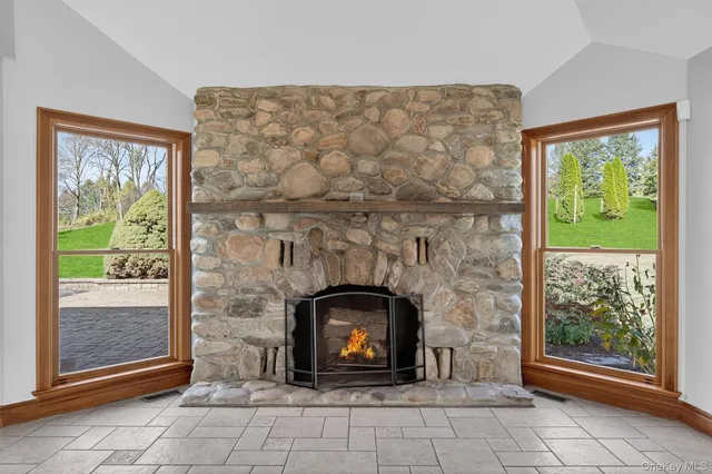 an empty room with windows and fireplace