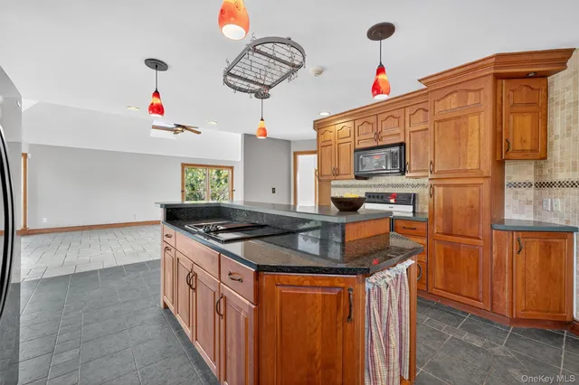 a kitchen with stainless steel appliances granite countertop a stove a sink and a refrigerator