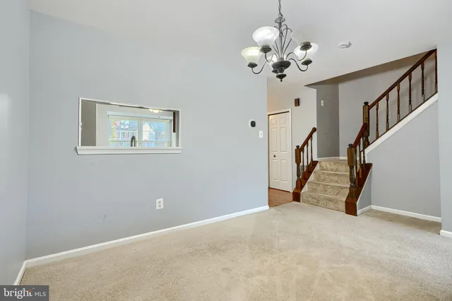 a view of an empty room with a chandelier fan