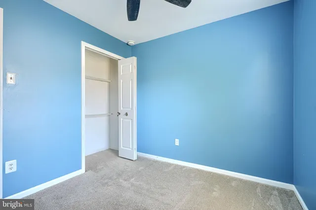 a view of a big room with windows and chandelier fan