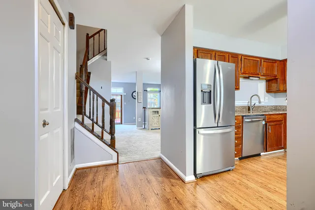 a view of kitchen with stainless steel appliances wooden floor and electronic appliances