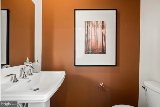 a bathroom with a sink and mirror with toilet