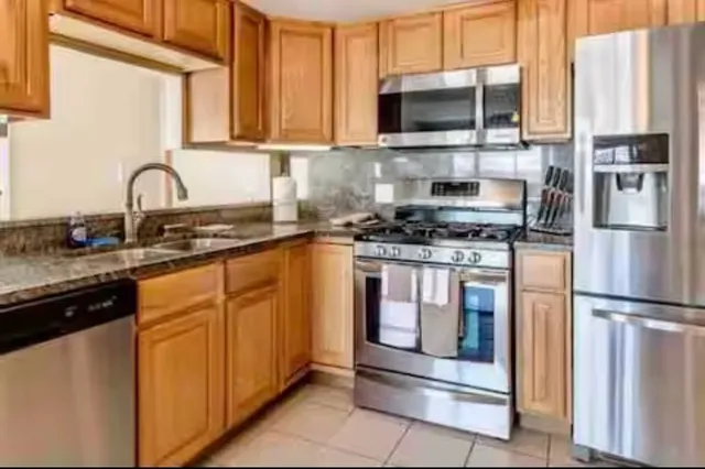 a kitchen with stainless steel appliances granite countertop a stove a sink and a microwave