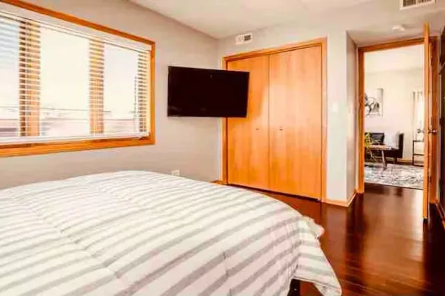 a bedroom with a bed and wooden floor