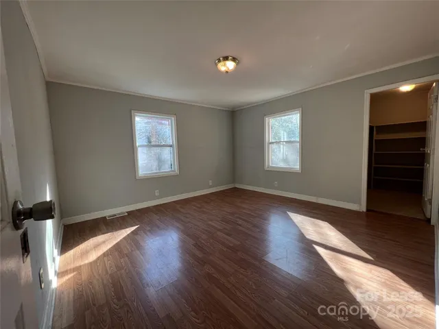 an empty room with wooden floor and window