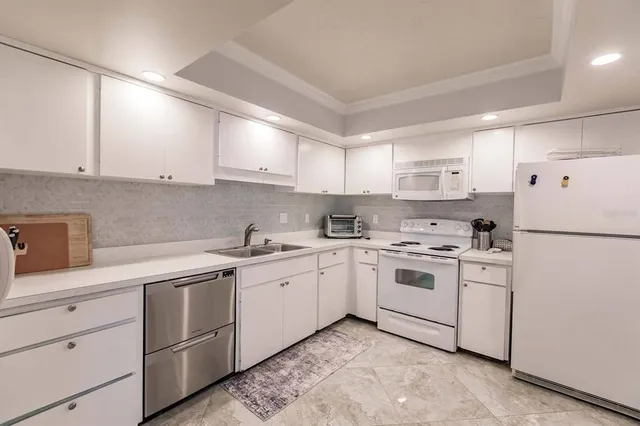 a kitchen with white cabinets sink and white appliances