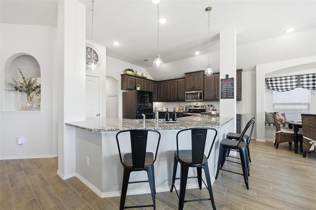 725 Sandy Chip Trail Fort Worth, TX 76108 - Photo 13 of 30 a kitchen with stainless steel appliances kitchen island granite countertop a dining table chairs and granite counter tops