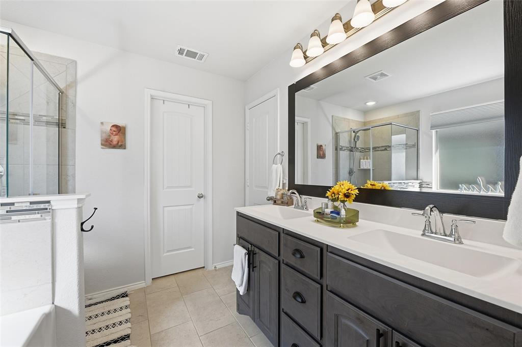 725 Sandy Chip Trail Fort Worth, TX 76108 - Photo 21 of 30 a bathroom with a double vanity sink a mirror and a shower