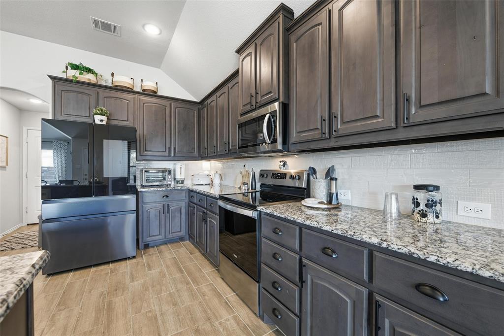725 Sandy Chip Trail Fort Worth, TX 76108 - Photo 9 of 30 a kitchen with stainless steel appliances granite countertop a sink stove and refrigerator
