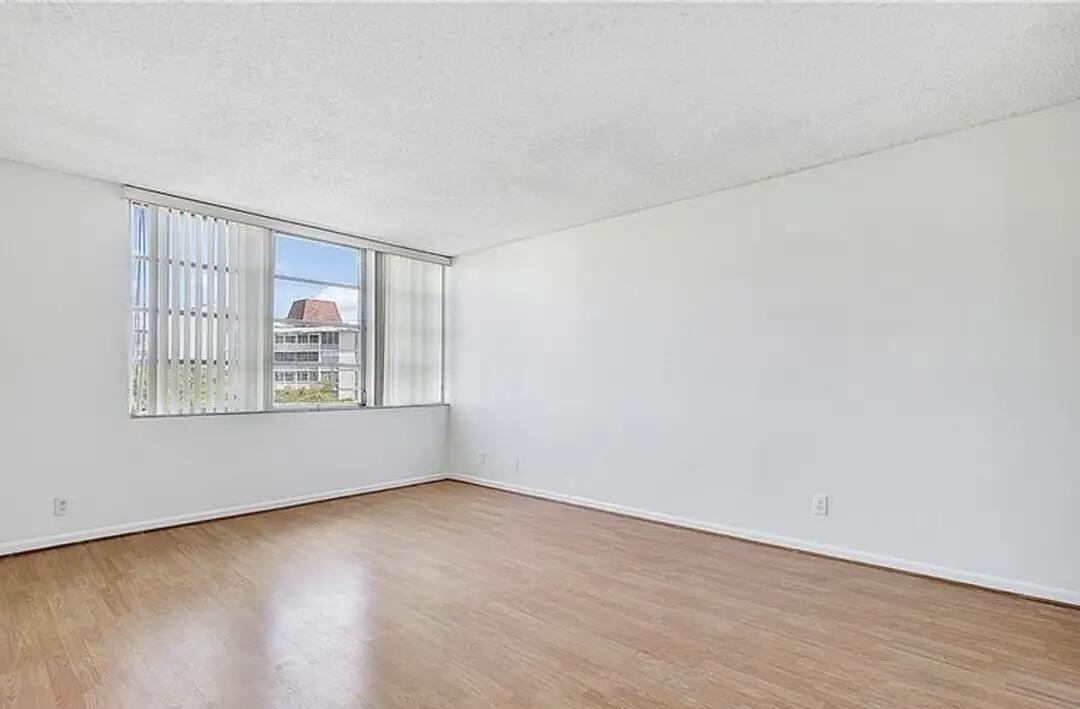 6921 Environ Boulevard, Unit 6S Lauderhill, FL 33319 - Photo 6 of 10 a view of an empty room with wooden floor and a window